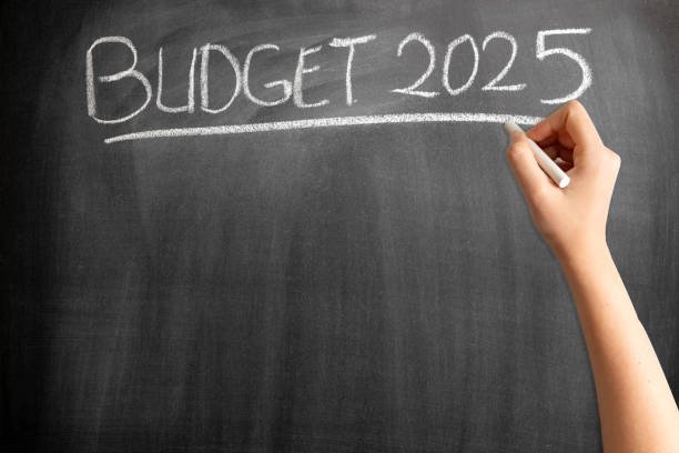 Budget 2025 on blackboard with woman hand